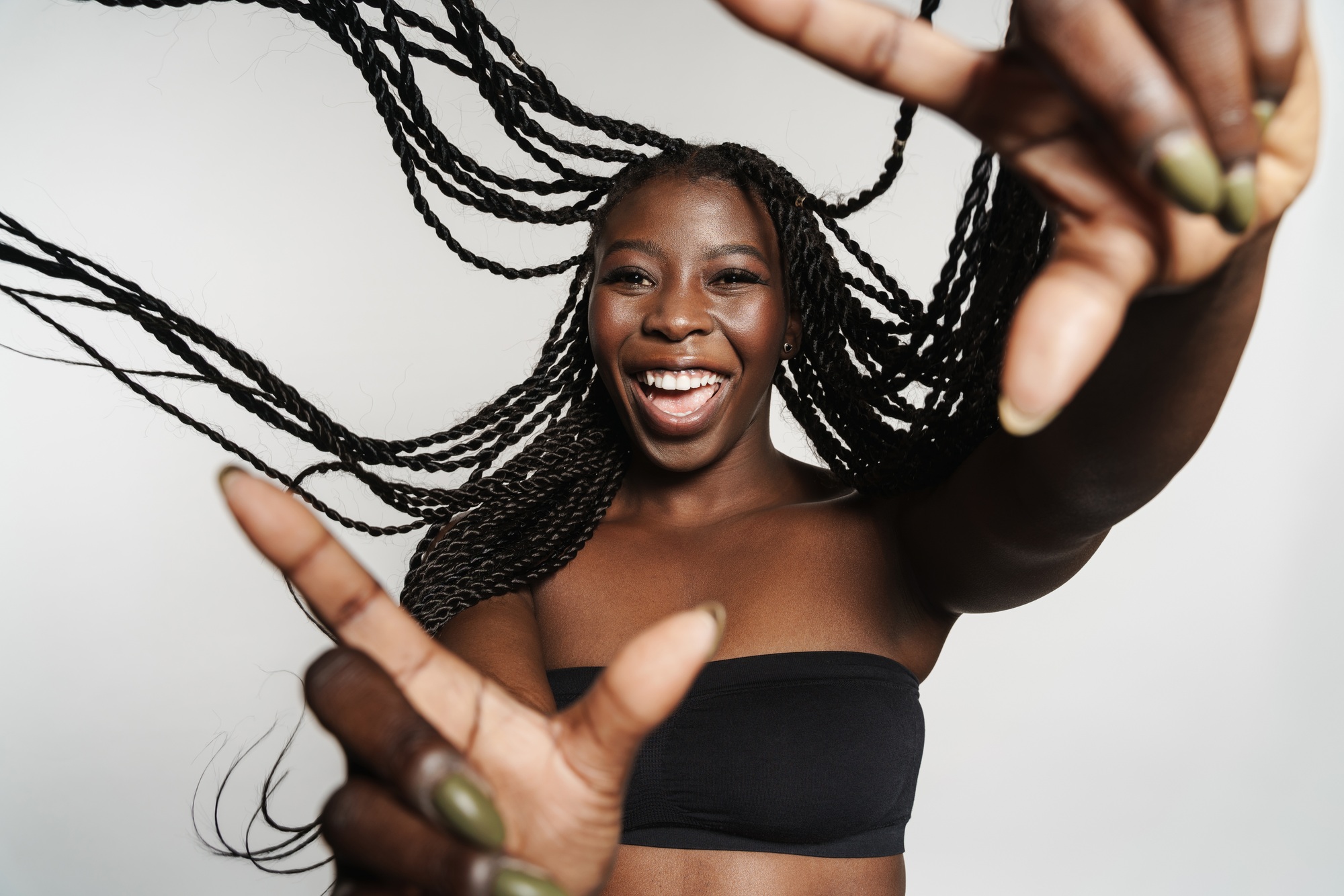 Black woman with afro pigtails laughing and gesturing at camera