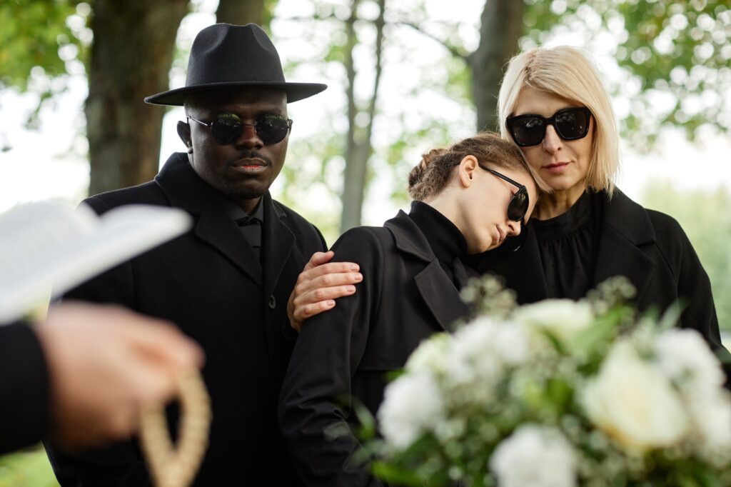 Mother and daughter embracing at outdoor funeral
